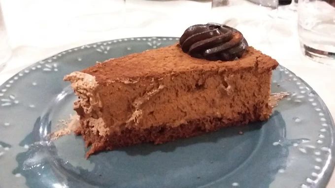 Una fetta di torta al cioccolato su un piatto blu