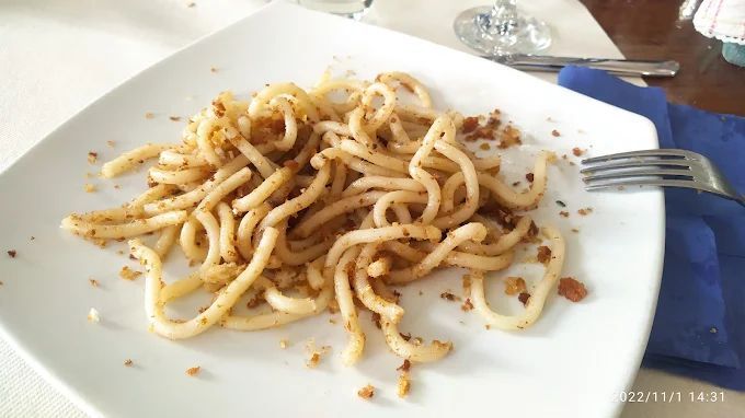 Un piatto bianco con sopra delle tagliatelle e una forchetta