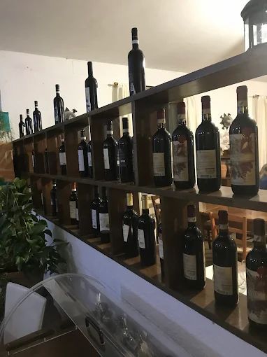Uno scaffale pieno di tante bottiglie di vino