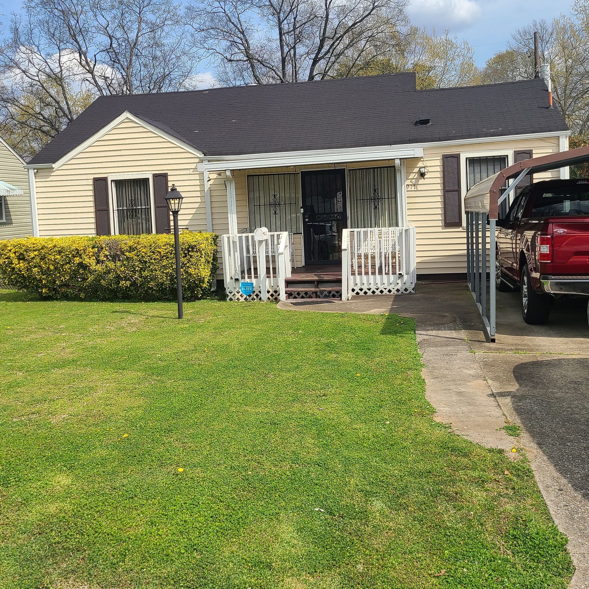 A red truck is parked in front of a house.