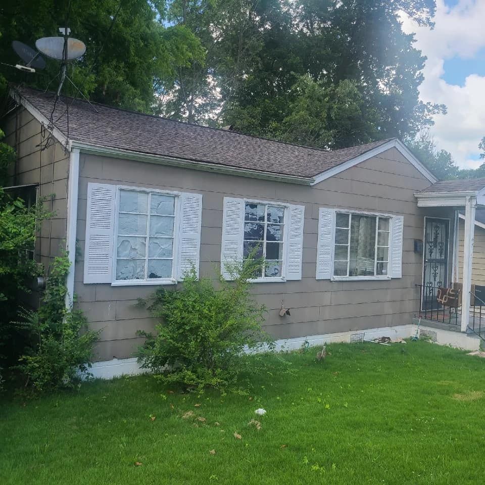 A small house with white shutters and a satellite dish on the roof