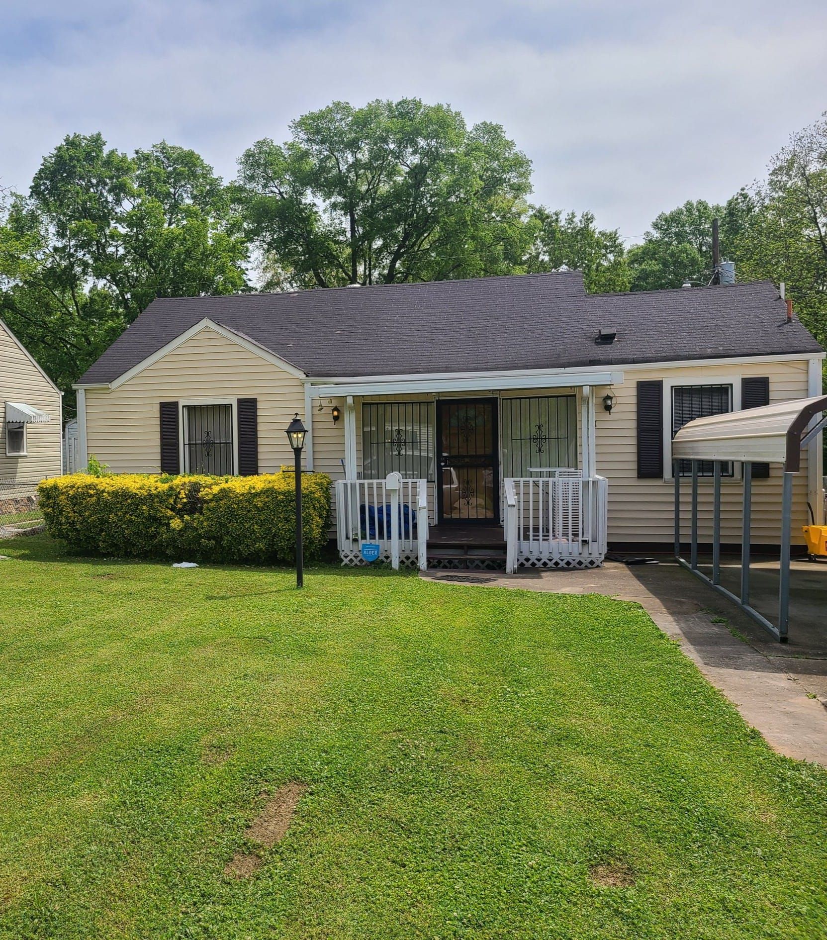 A small house with a large lawn in front of it