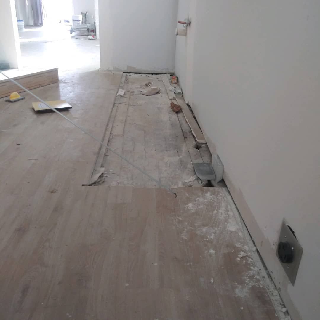 A room with a wooden floor and a white wall.