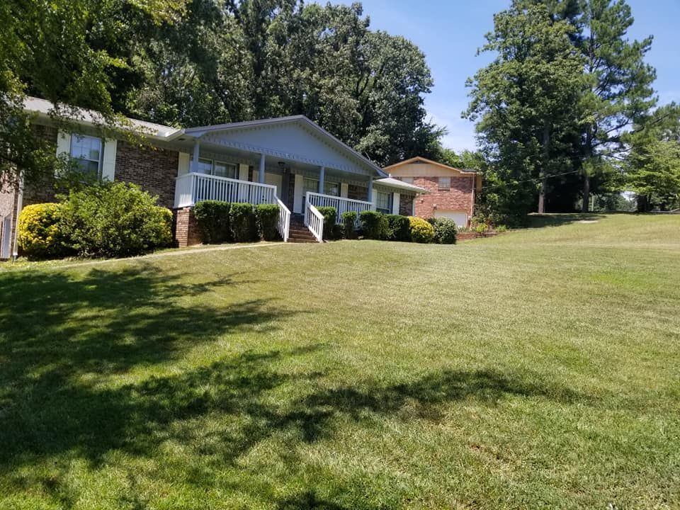 A house with a large lawn in front of it.