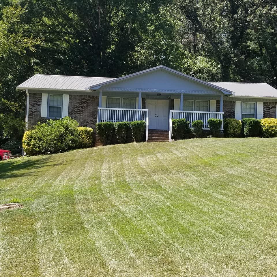 A house with a lush green lawn in front of it