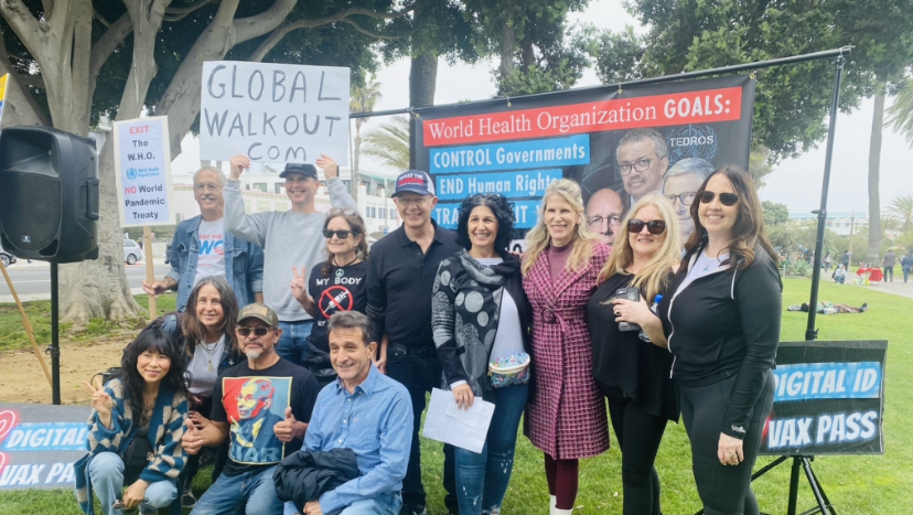 Group of people protesting, holding signs. One sign says 