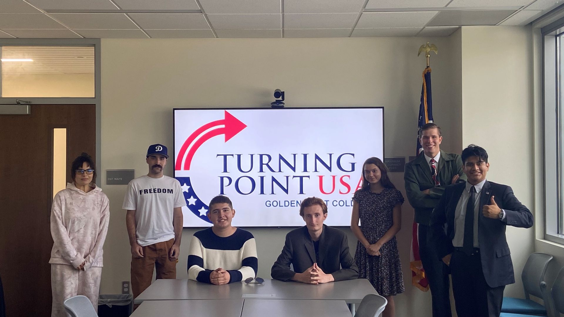 Group of people standing in front of a Turning Point USA sign at Columbia College.
