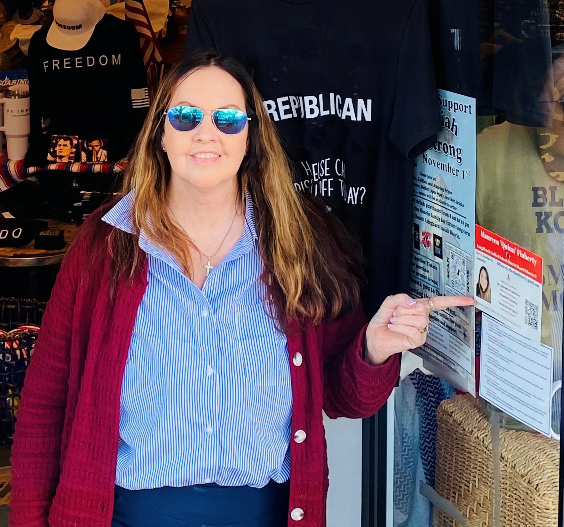 Woman in sunglasses points toward a store window with a