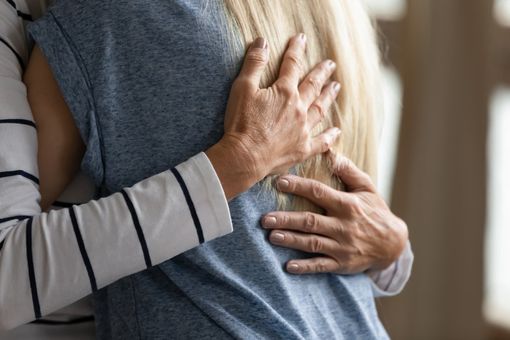 A man is hugging a woman in a blue shirt.