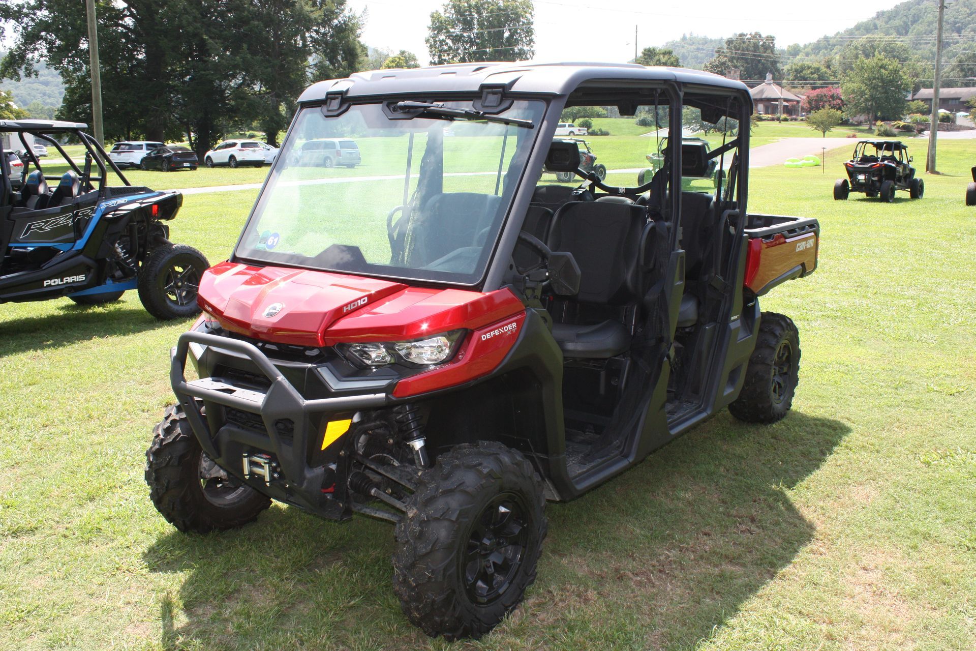 A red and black atv is parked in a grassy field.