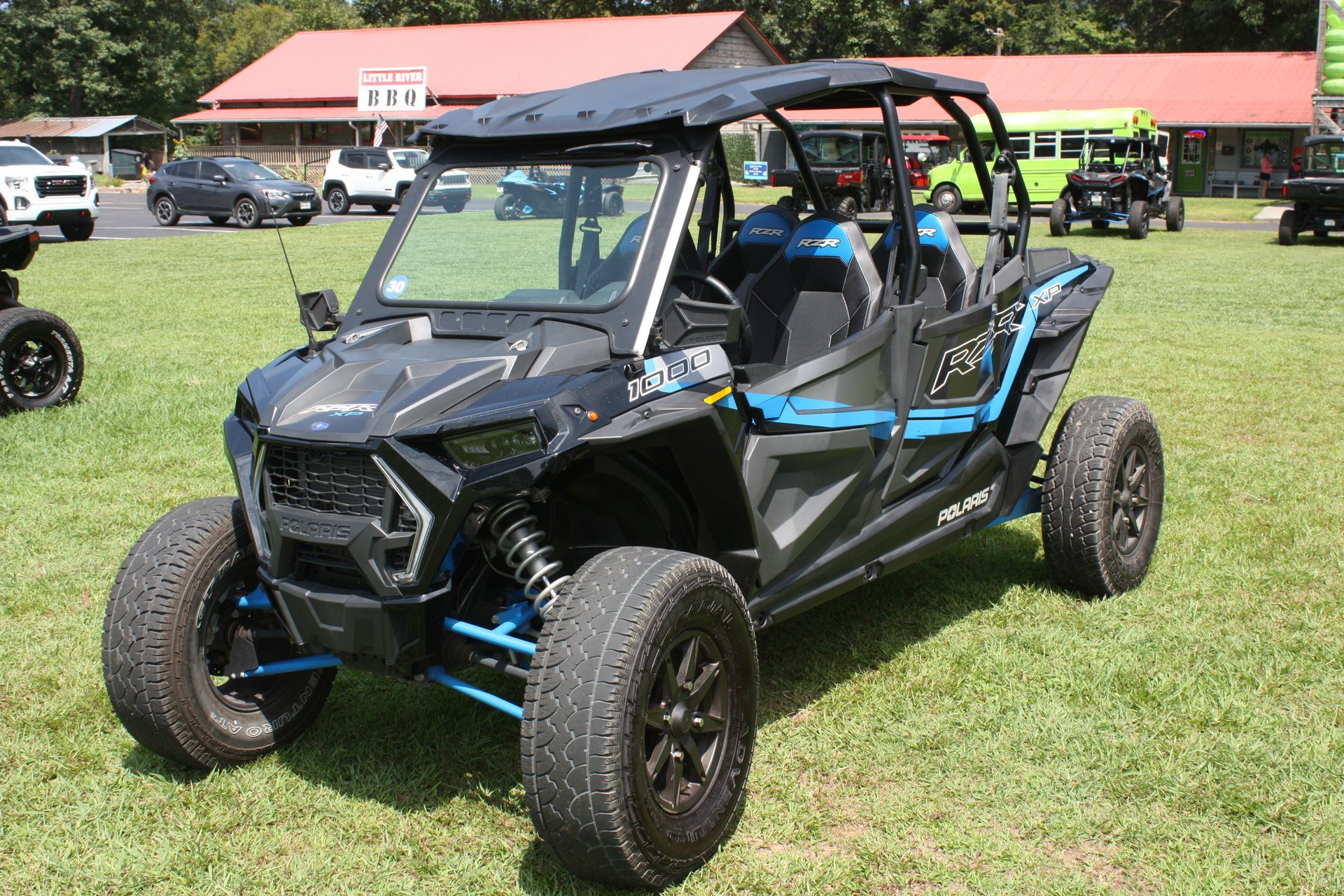 A black and blue atv is parked in a grassy field.