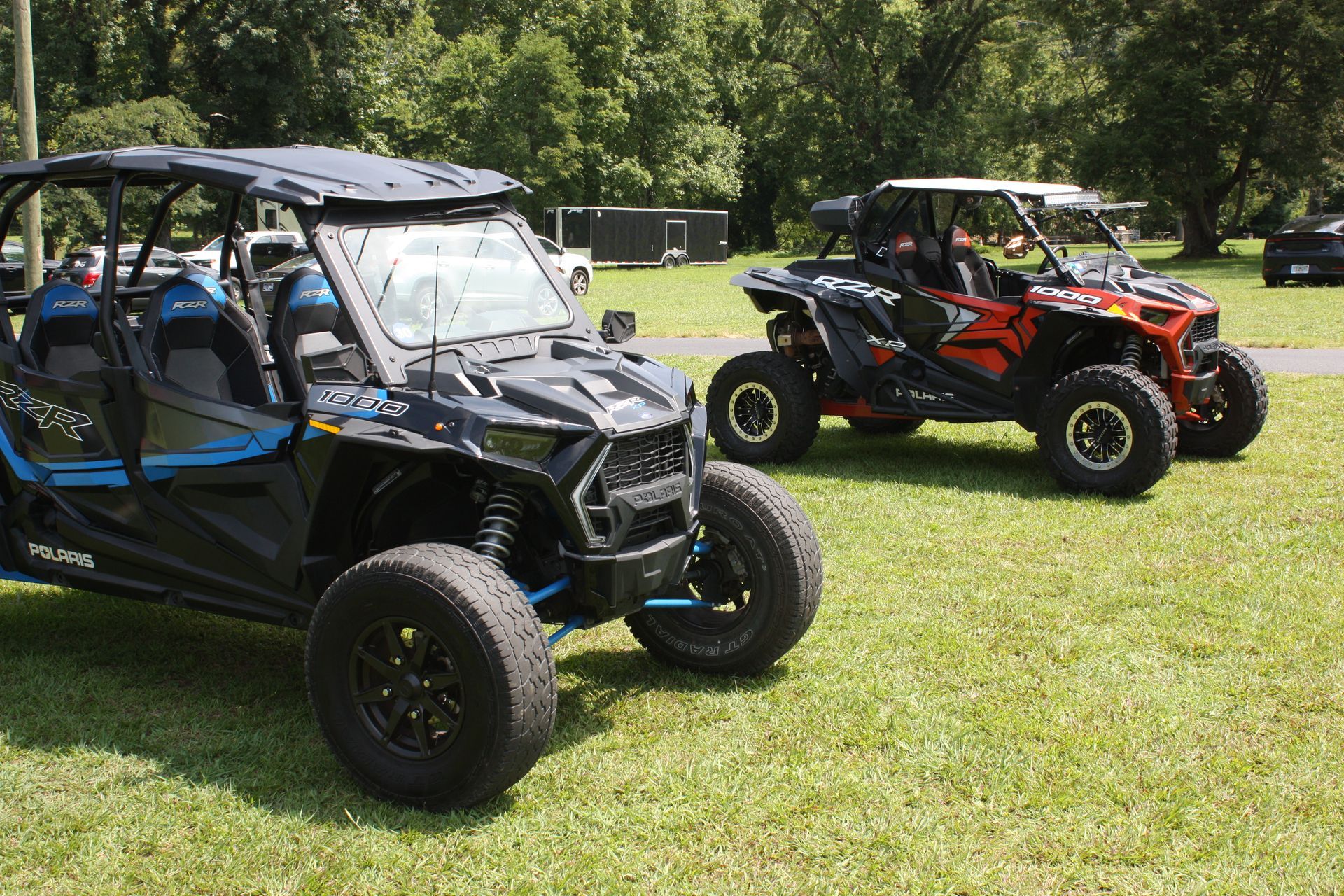 Three atvs are parked in a grassy field.