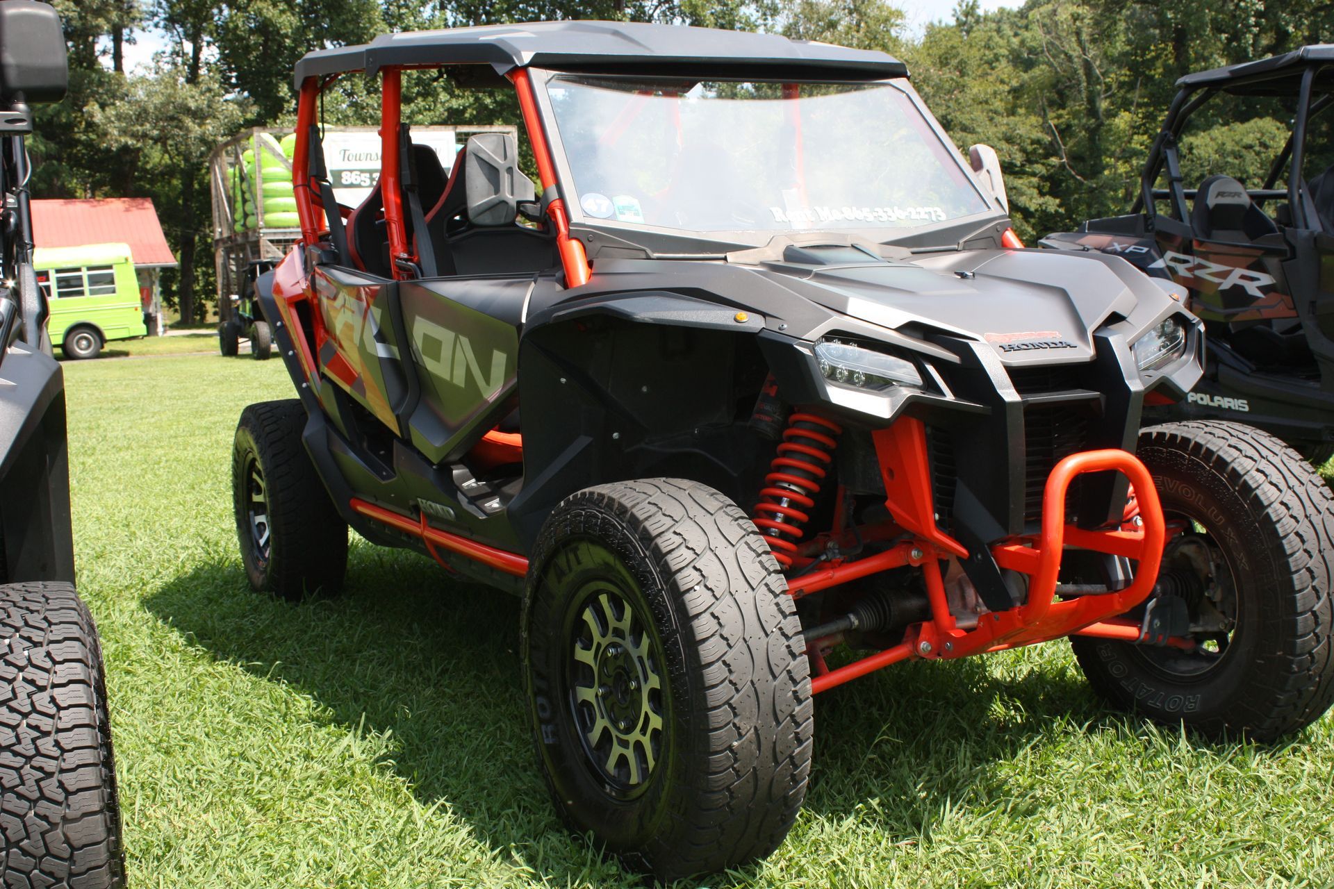 A black and orange atv is parked in the grass