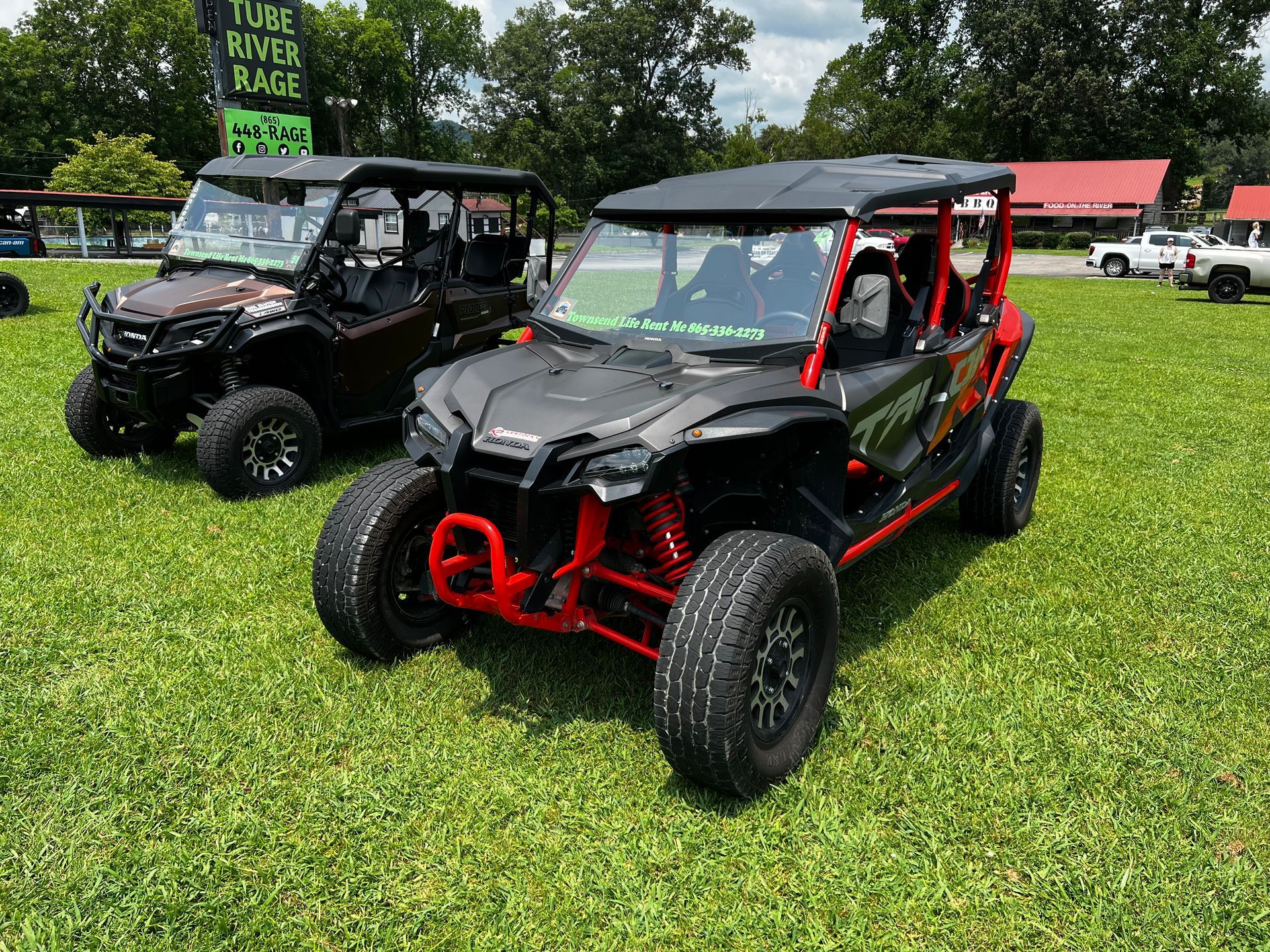 Two atvs are parked in a grassy field.