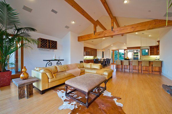 A living room with a yellow couch and a cowhide rug