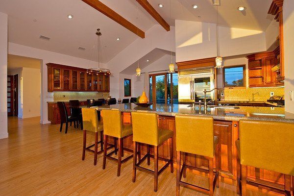 A kitchen with a bar and yellow chairs