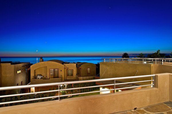 A view of the ocean from a balcony with a railing.