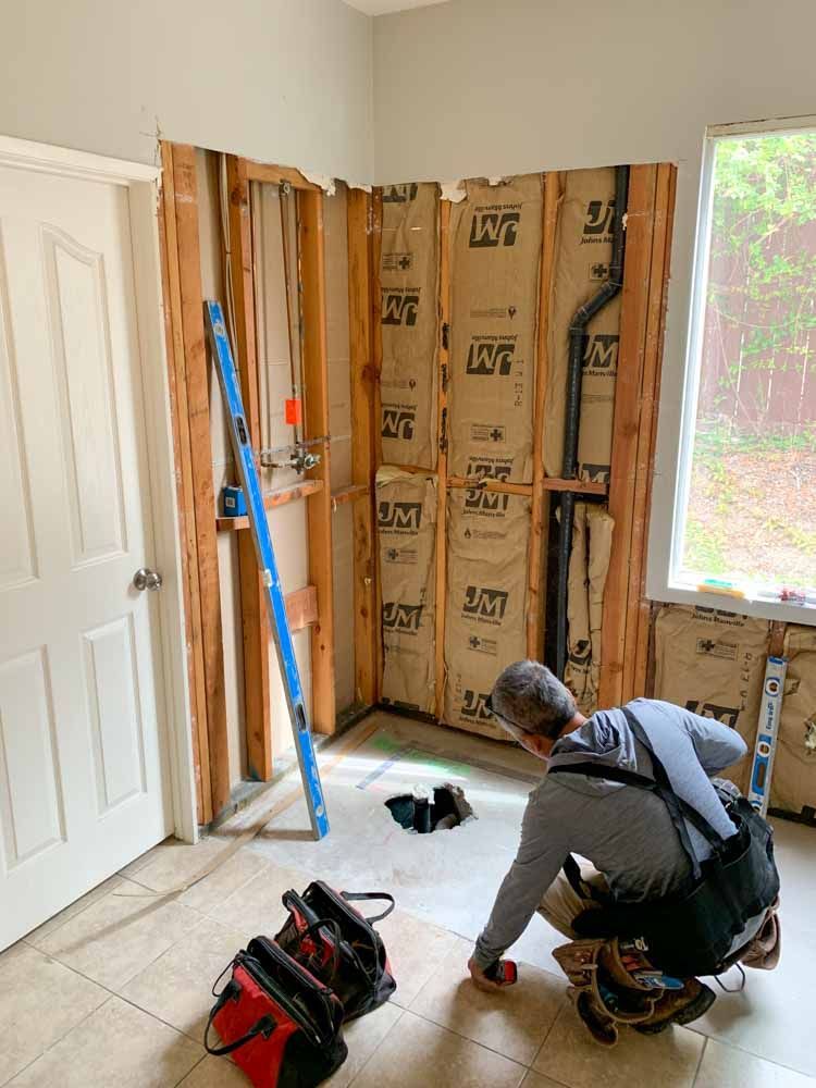 A man is kneeling on the floor in a room.