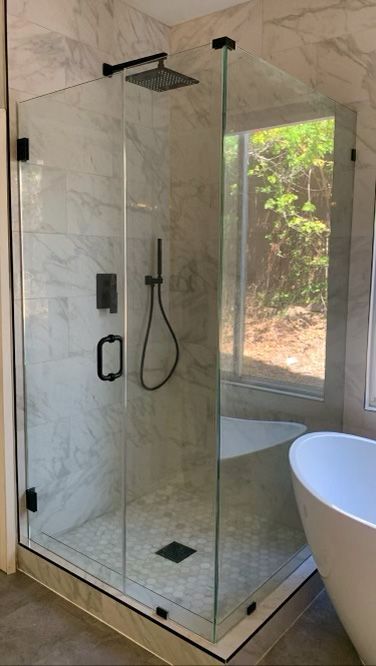 A bathroom with a walk in shower and a bathtub.