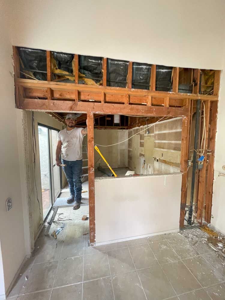 A man is standing in a room with a hole in the wall.