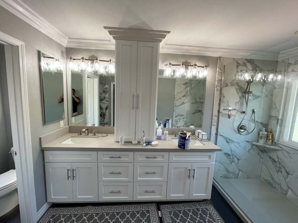 A bathroom in Vista, CA with two sinks , two mirrors and a shower.