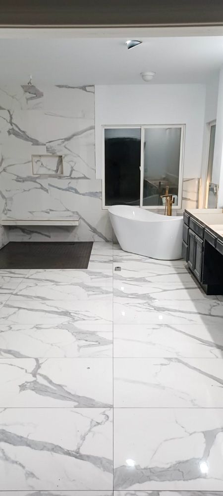 A bathroom with a tub , sink , and shower.