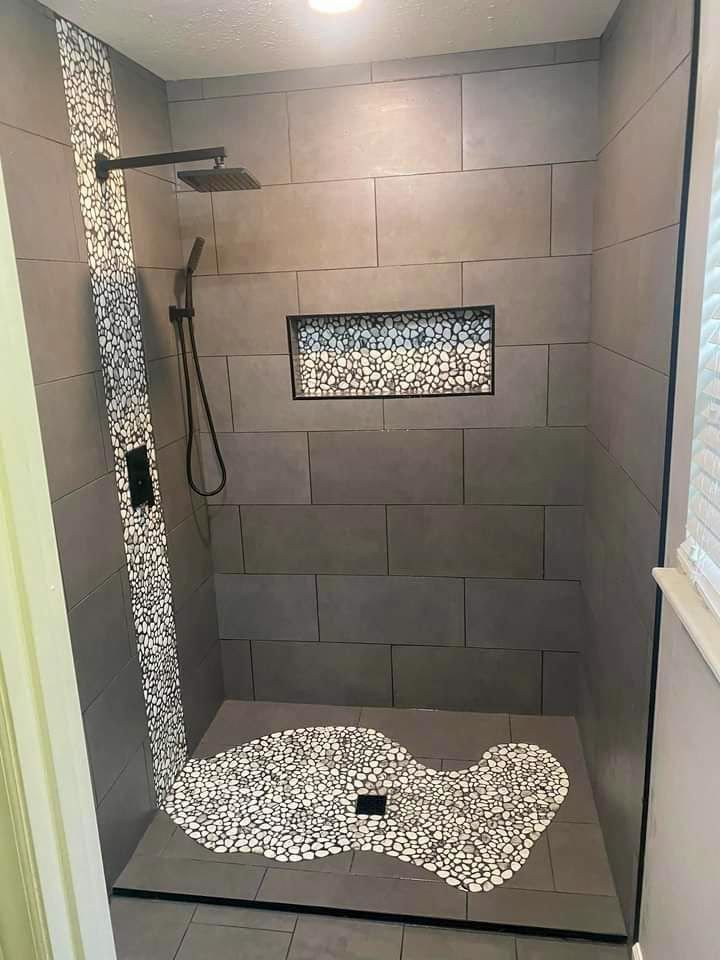 A bathroom with a walk in shower and a rug on the floor.