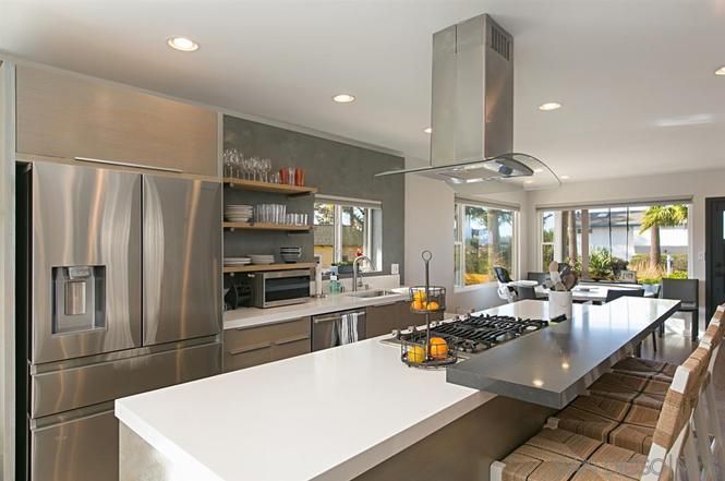 A kitchen with stainless steel appliances and a large island.