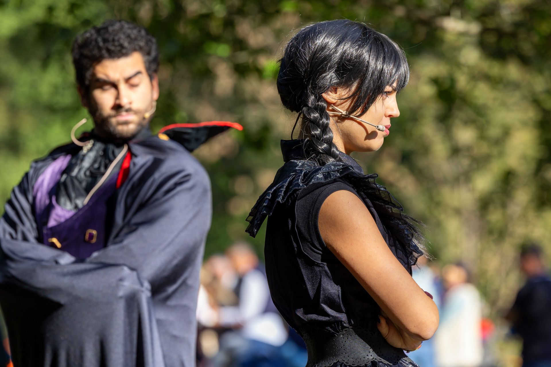 Un uomo in costume da vampiro e una donna in abito nero sono in piedi uno accanto all'altra.