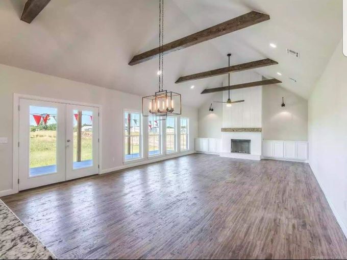 an empty living room with hardwood floors and a fireplace