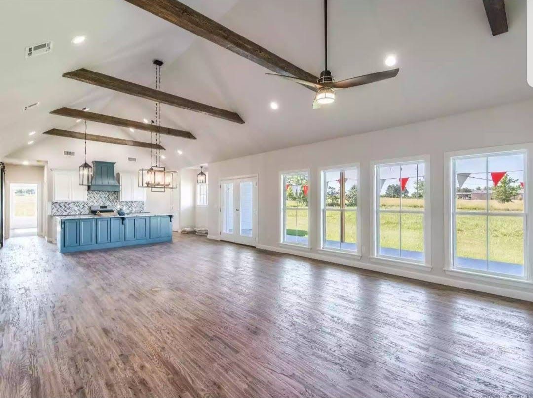 a large empty room with a ceiling fan and a lot of windows