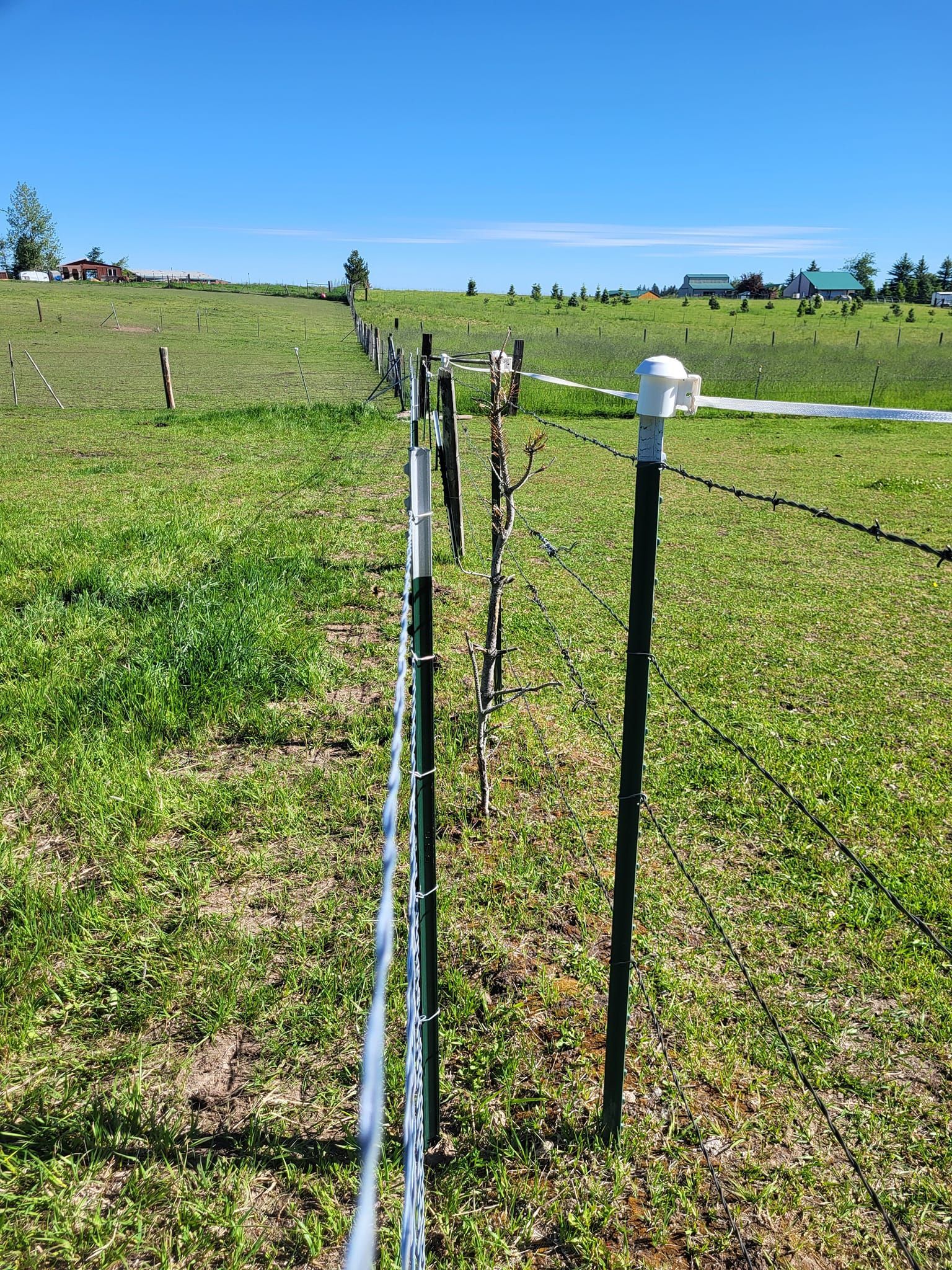 There is a fence in the middle of a grassy field.