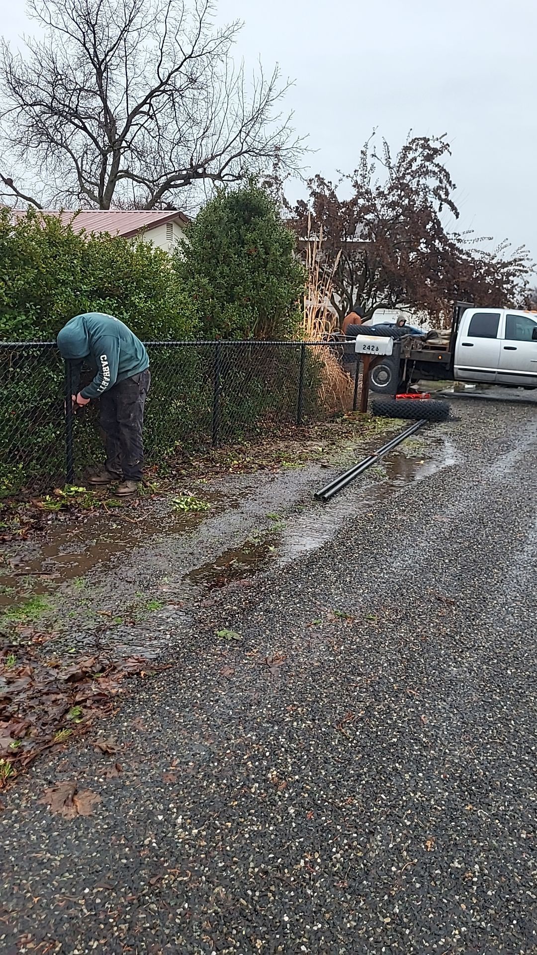 A man is cutting a fence with a chainsaw.