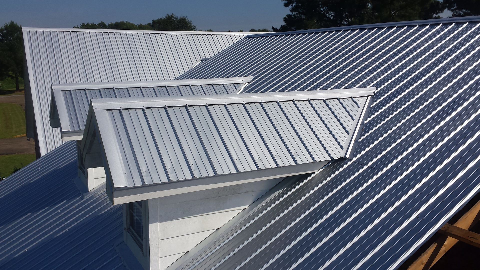 Metal roof with ridged panels reflecting sunlight.