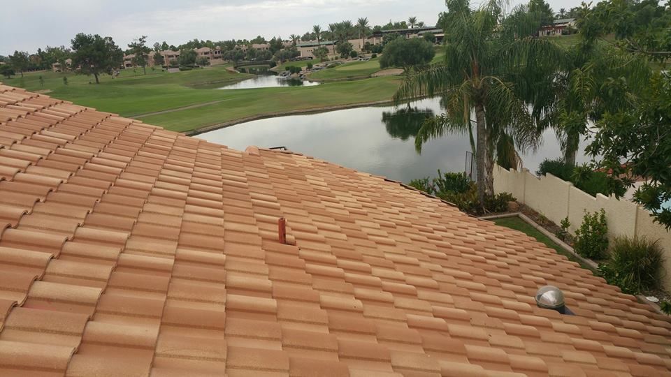 Clay tile roof overlooking a golf course and lake, with a white fence.