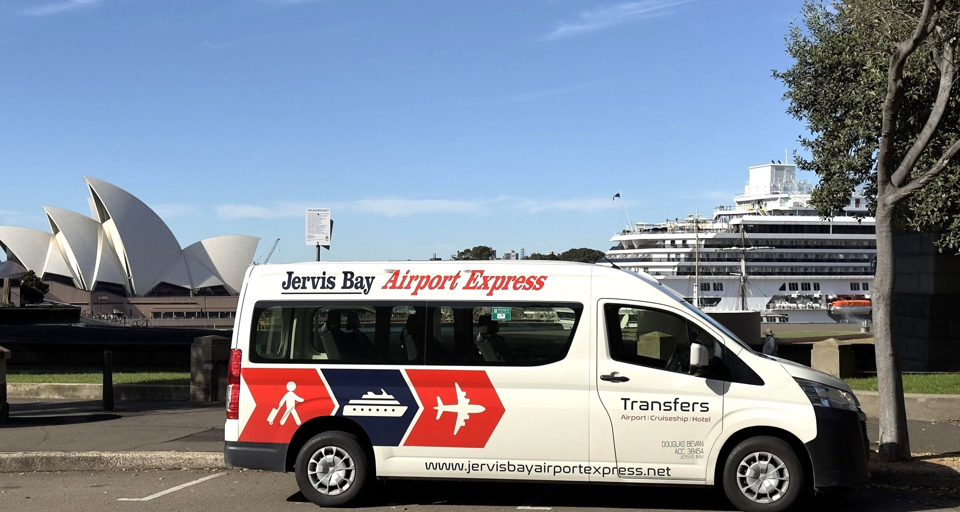 Jervis Bay Airport Express shuttle parked in Sydney, with the Opera House in view in the background.