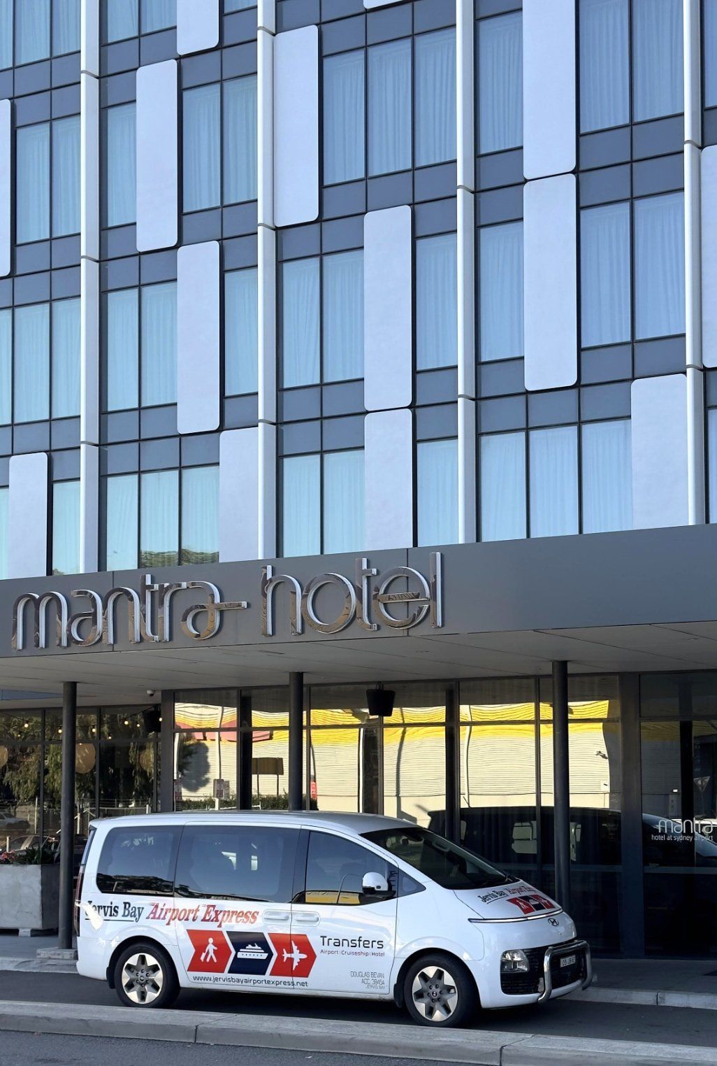 A White Van With Its Doors Open Is Parked In A Parking Lot — Jervis Bay Airport Express In Swanhaven, NSW