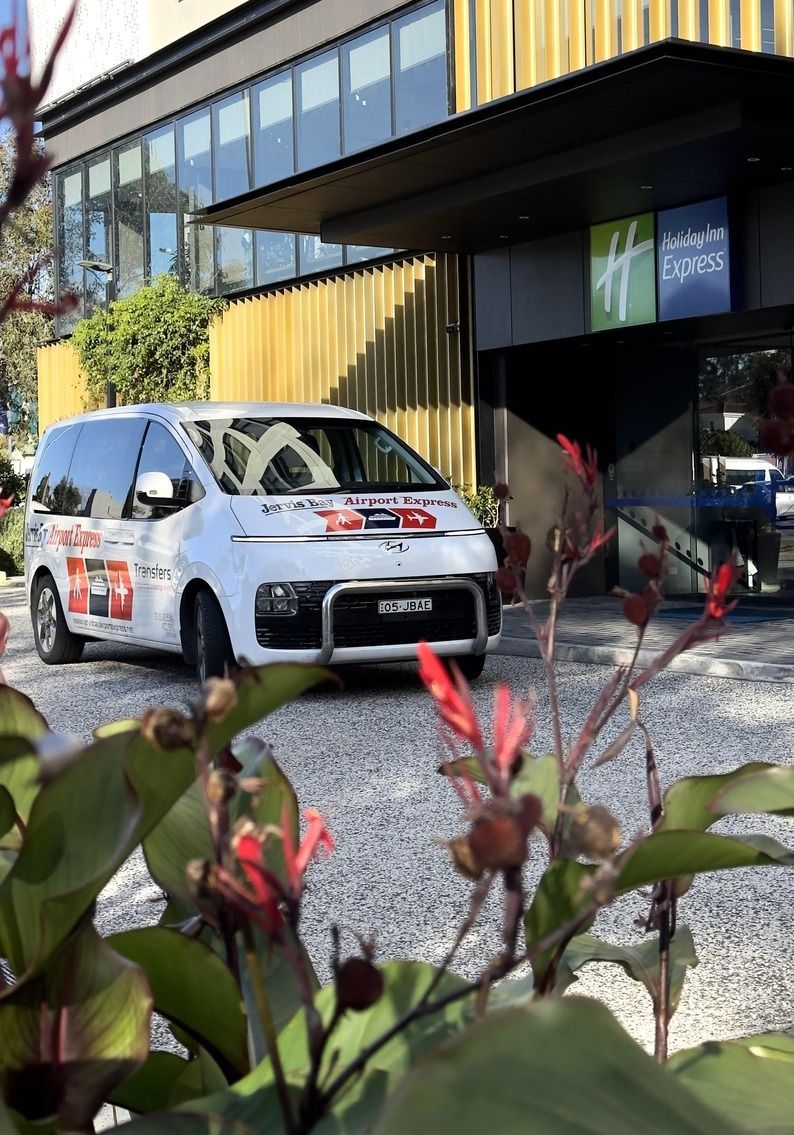 A Bunch Of Luggage Is Sitting On The Ground At An Airport — Jervis Bay Airport Express In Swanhaven, NSW