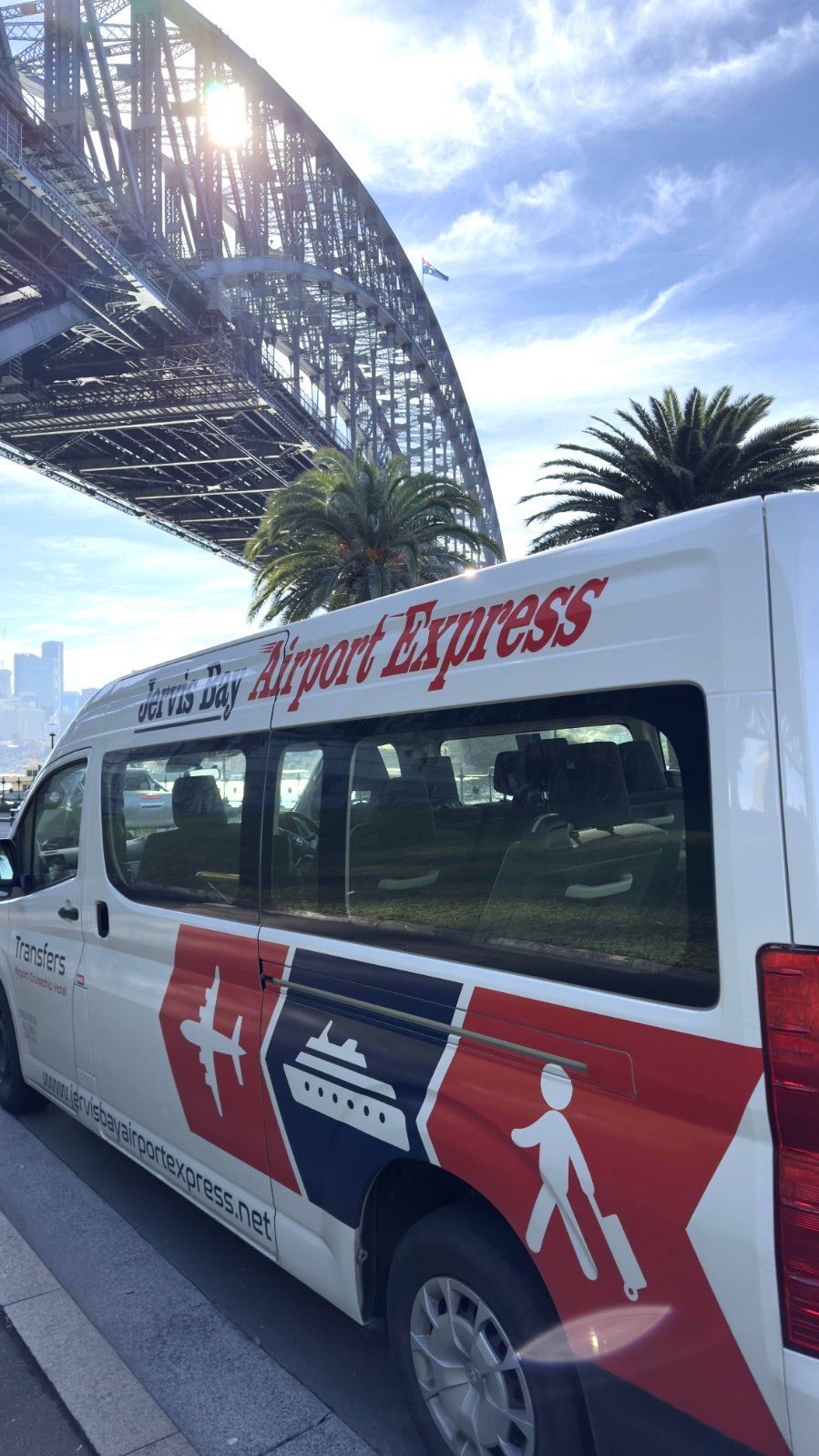 A Man Is Driving A Van With A Woman And A Man In It — Jervis Bay Airport Express In Swanhaven, NSW