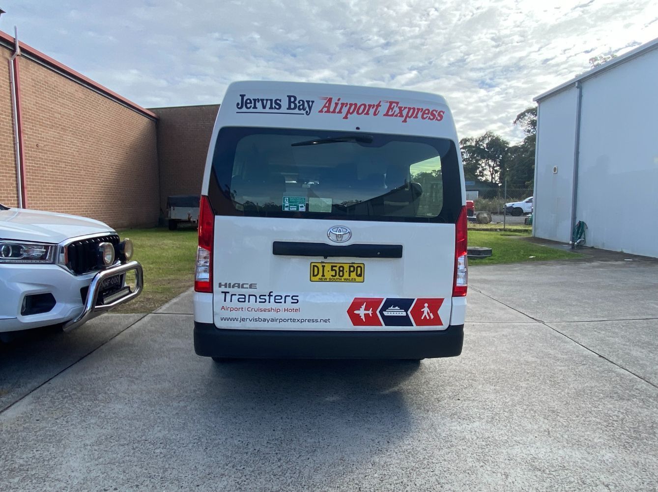 A White Bus Is Parked On The Side Of The Road — Jervis Bay Airport Express In Shellharbour, NSW