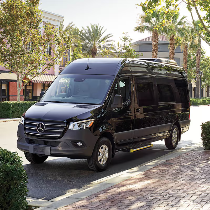 A black mercedes sprinter van is parked on the side of the road.