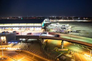 An aerial view of an airport at night with cars parked on the tarmac.