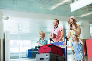A family is pulling luggage on a cart at the airport.