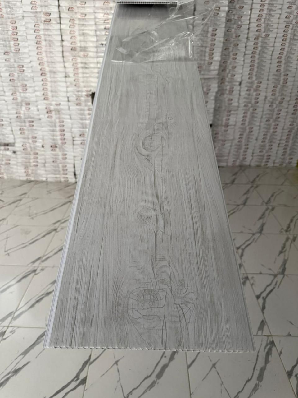 Un largo trozo de madera reposa sobre un suelo de mármol.