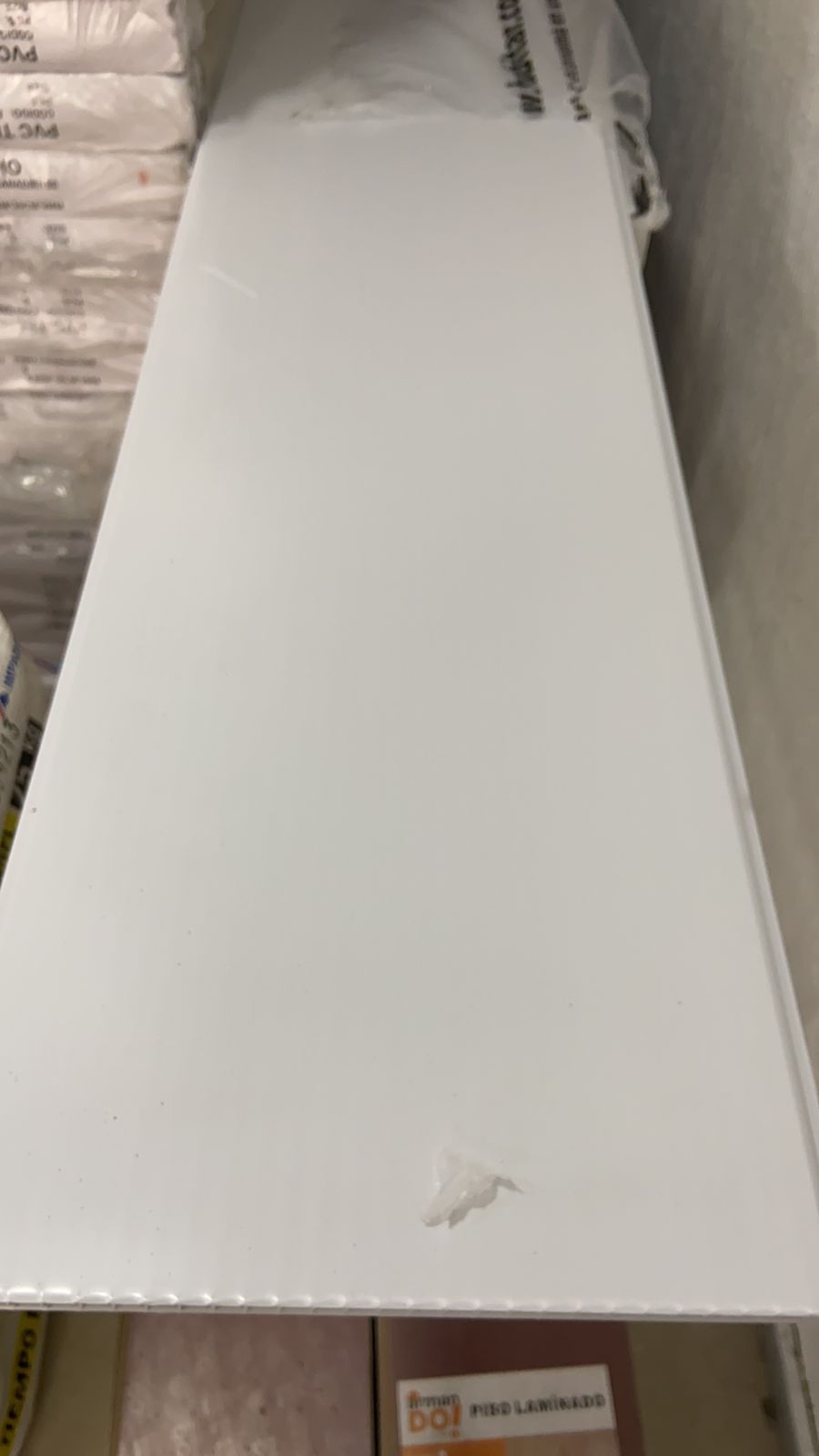 Una lámina blanca de plástico reposa sobre un estante.