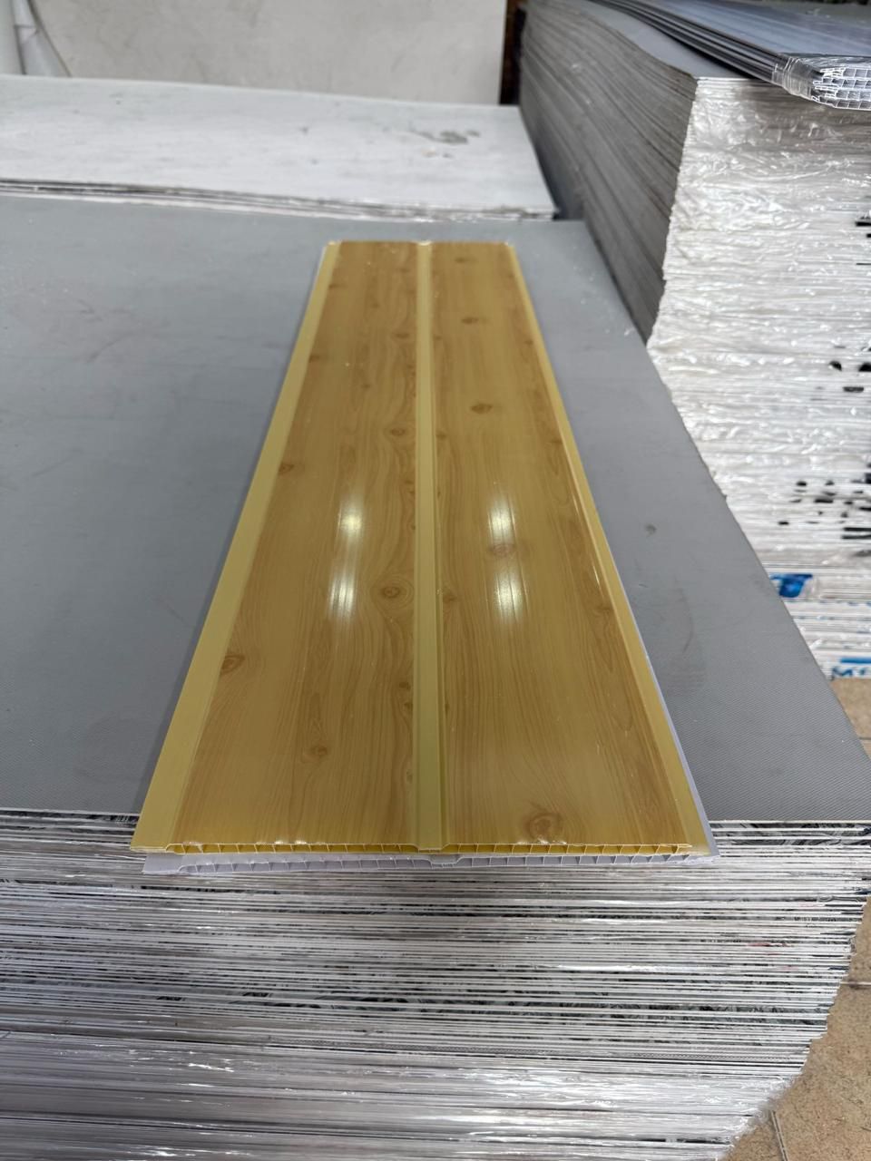 Un trozo de madera reposa sobre una pila de láminas de plástico.