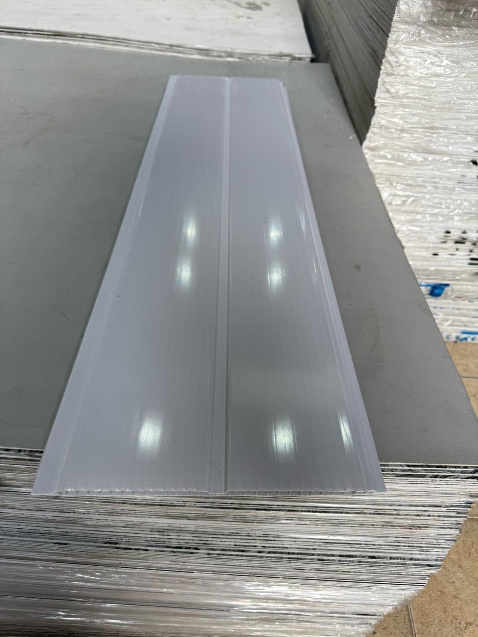 Un trozo de plástico se encuentra encima de una pila de láminas de plástico.