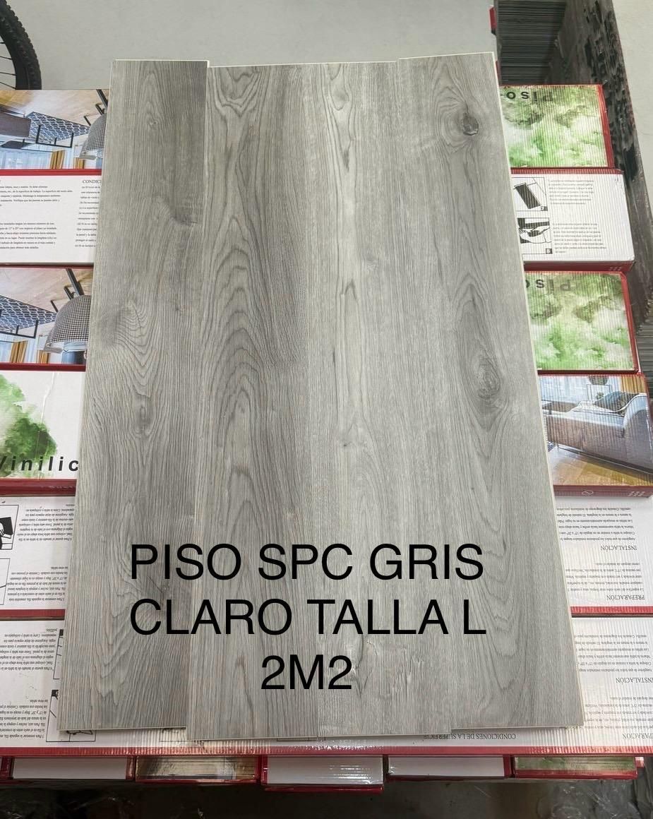 Un trozo de piso spc gris claro talla l 2m2 está colocado encima de una pila de cajas.