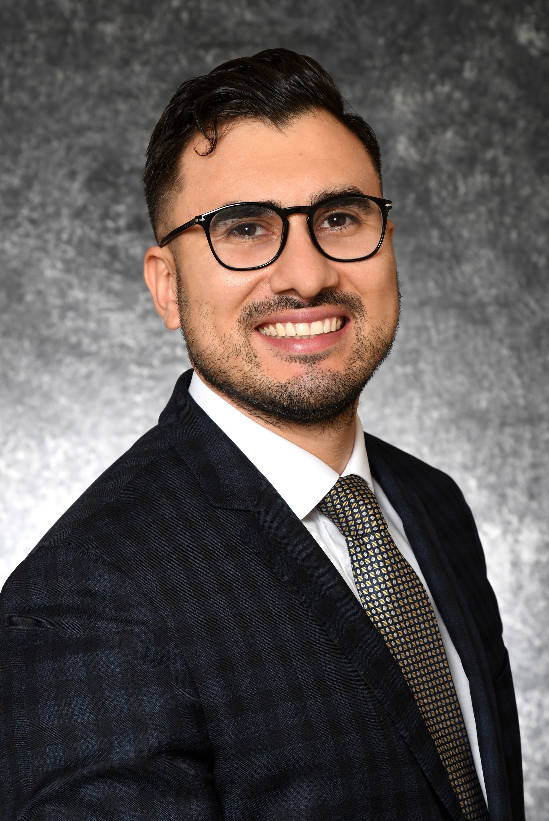 A man in a suit and tie is smiling for the camera. A man in a suit and tie is smiling for the camera.