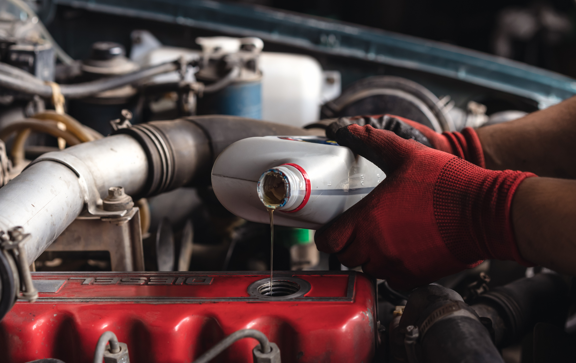 A person is pouring oil into a car engine.
